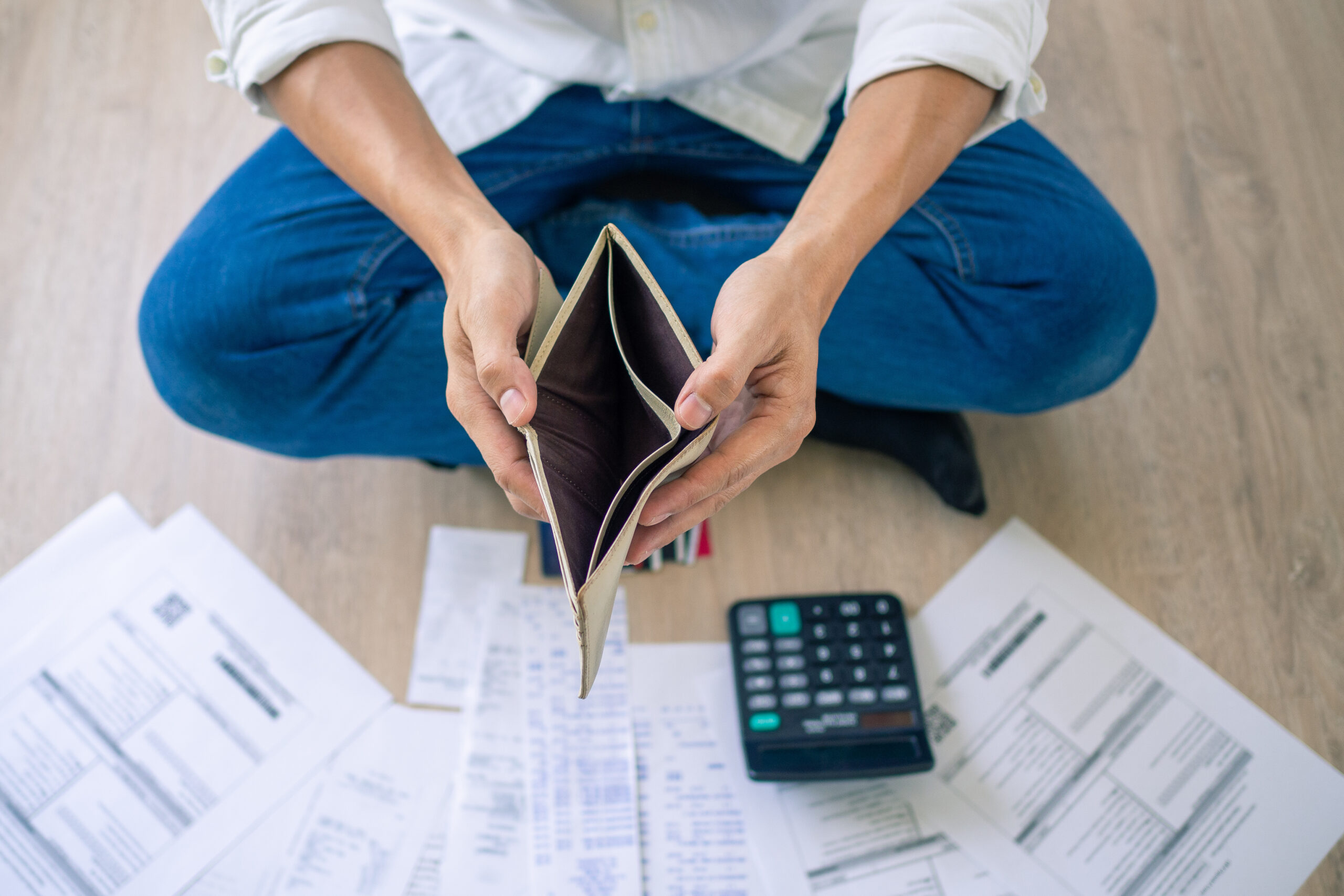A businessman who is sitting on the floor of the house opening t