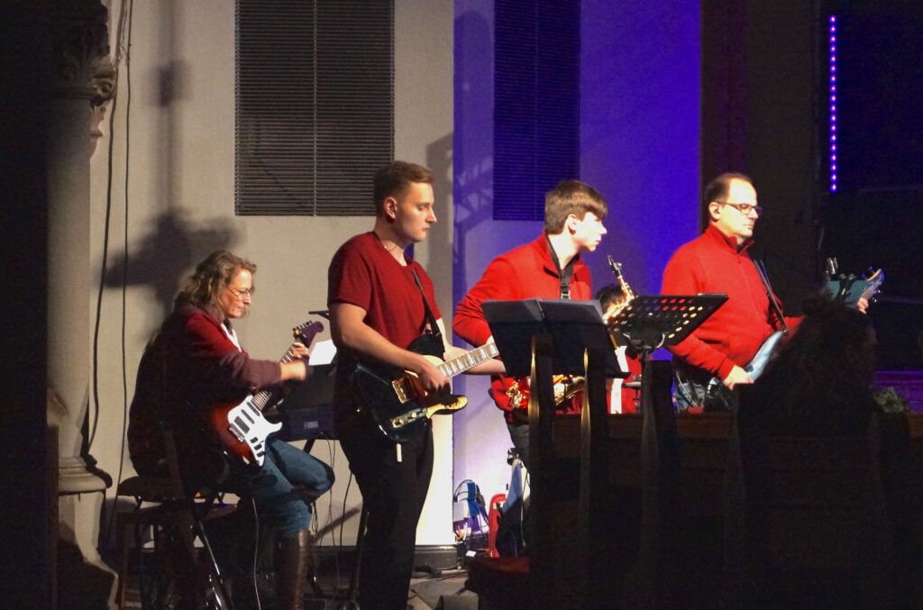 Eine rotgekleidete Band in einem abgedunkelten Raum